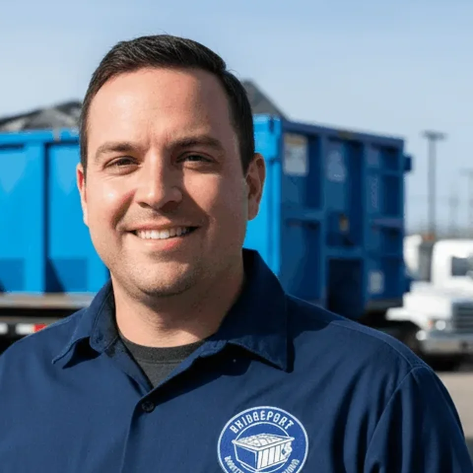 Marcus Bellamy, Driver at Bridgeport Dumpster Rental Solutions, standing beside a loaded roll-off container